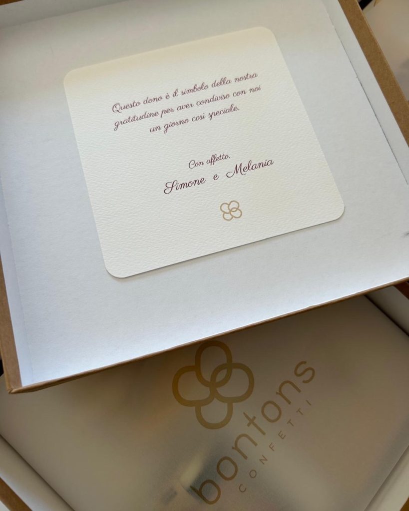 Biglietto di ringraziamento degli sposi sopra la scatola con il marchio Bontons Confetti