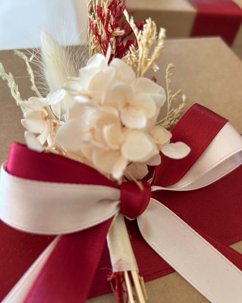 Scatola kraft con fiocco bordeaux e avorio e fiori stabilizzati